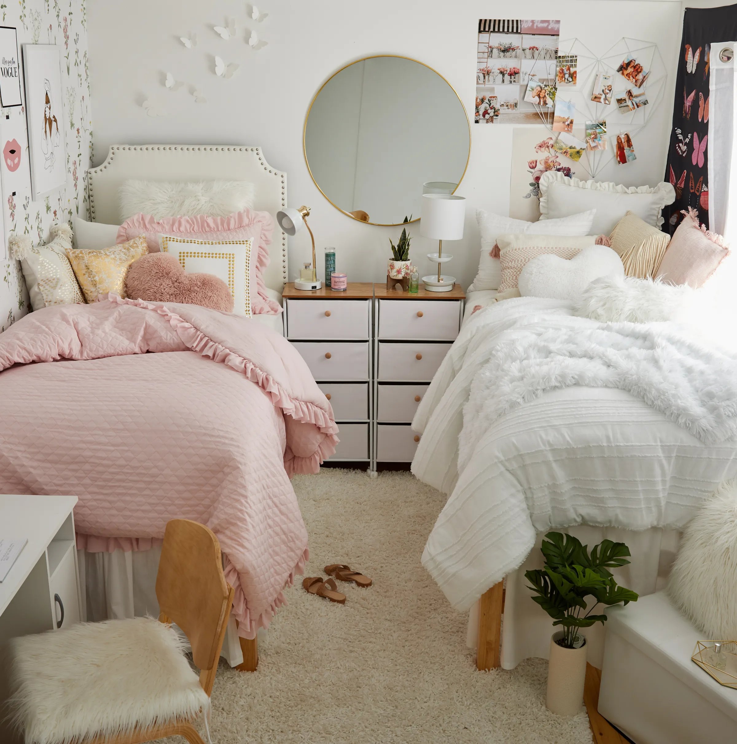 Nicely decorated dorm room with pink and white bedding, gallery wall, and round mirror